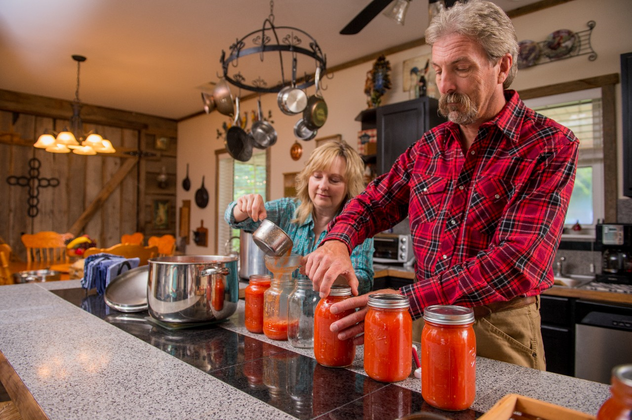 Image of two people preparing canning jars for a water bath canner.