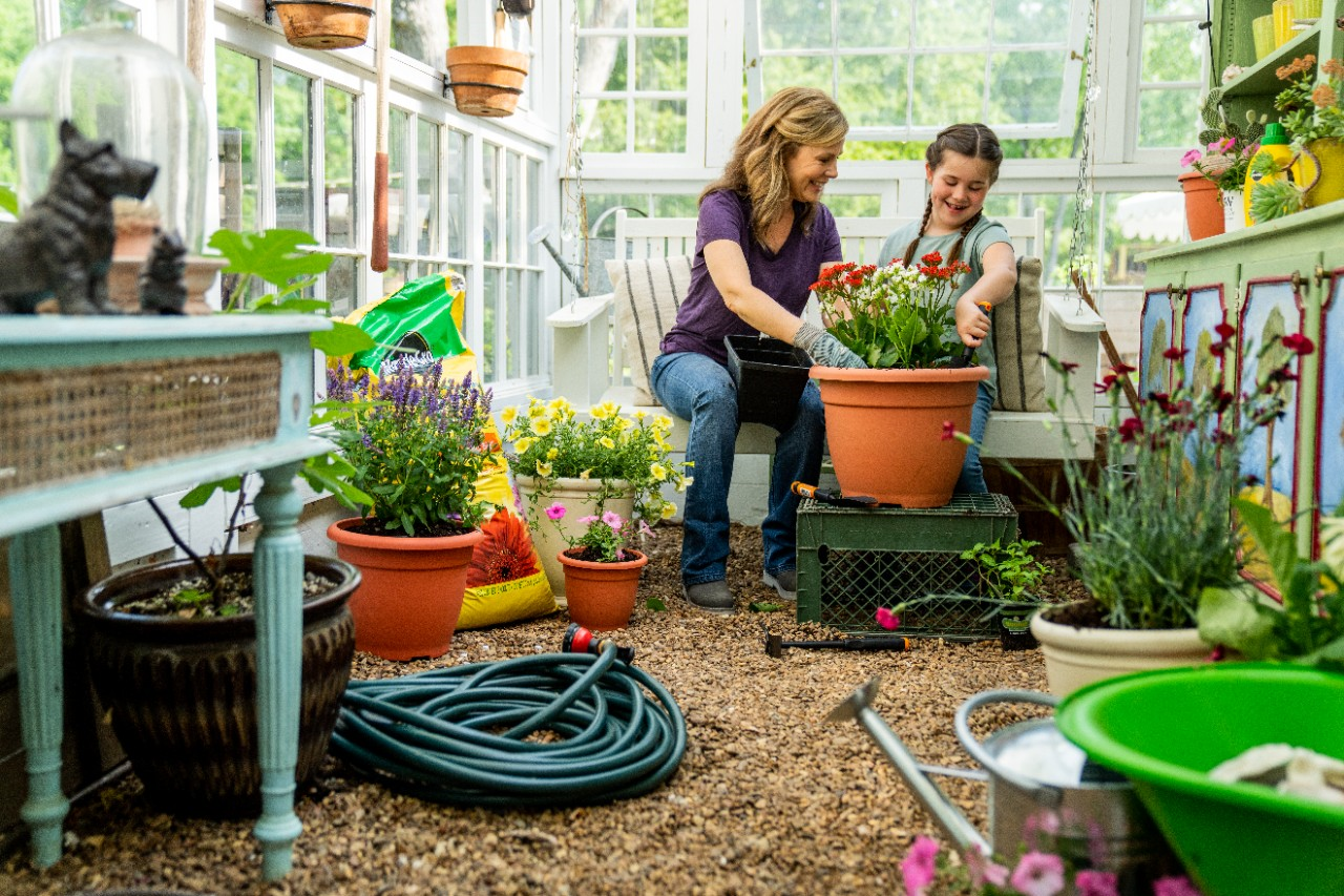 Image of two people planting in a greenhouse.