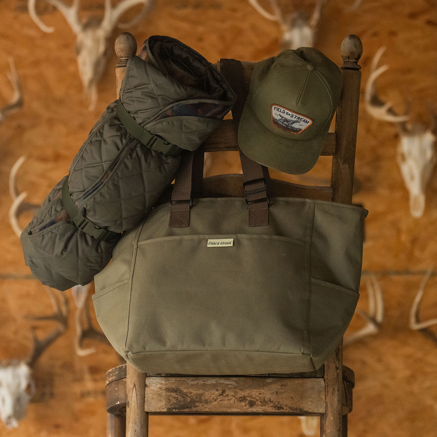 A chair with a Field and Stream canvas tote bag, baseball cap and a folded mat. See and shop items.