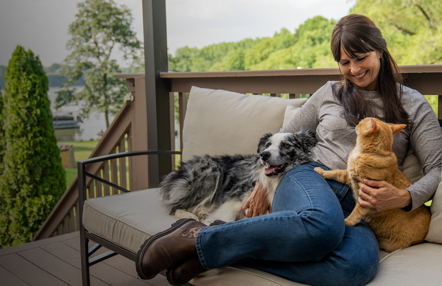 Just in for pets banner with text, Fetch something new for them to love, featuring a woman sitting outside with a dog and cat. Shop now. 