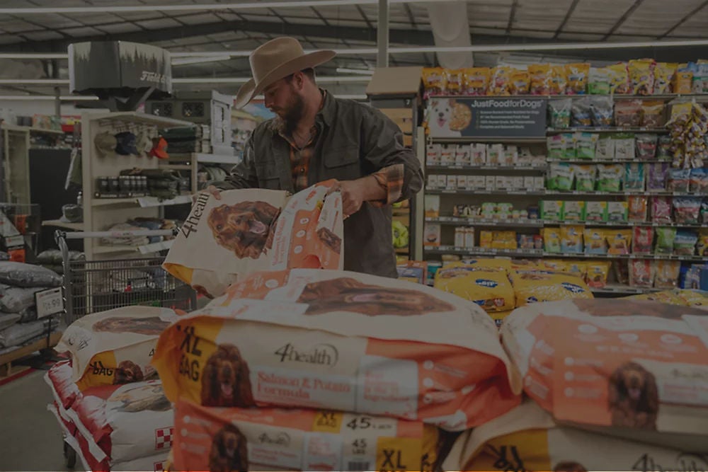 Tractor Supply team member greeting a dog in-store