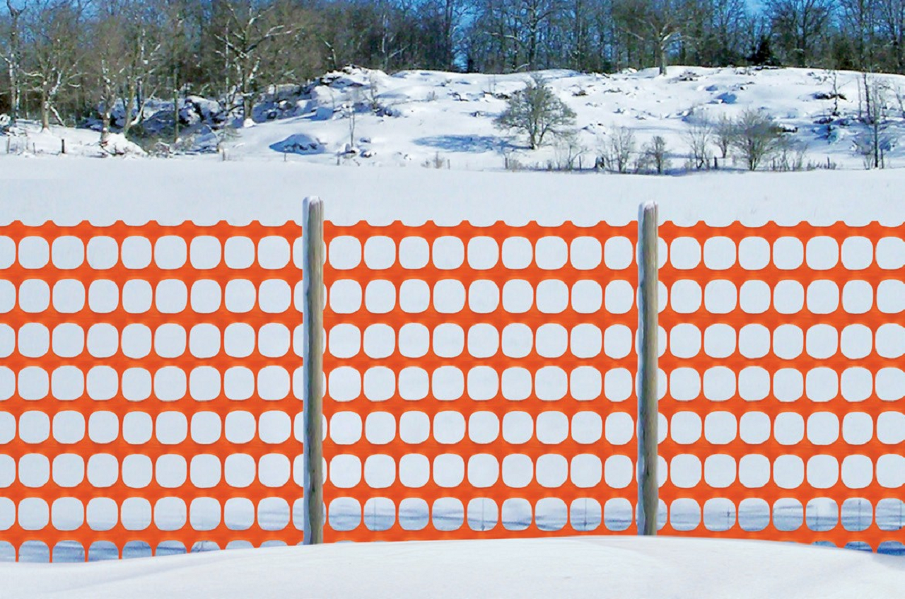 Image of an orange mesh fence in snow.