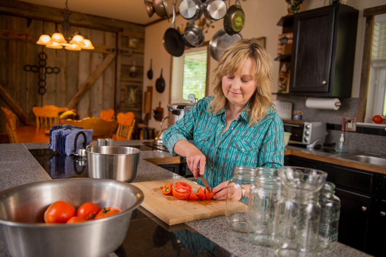 Image of a person preparing tomatoes to can.