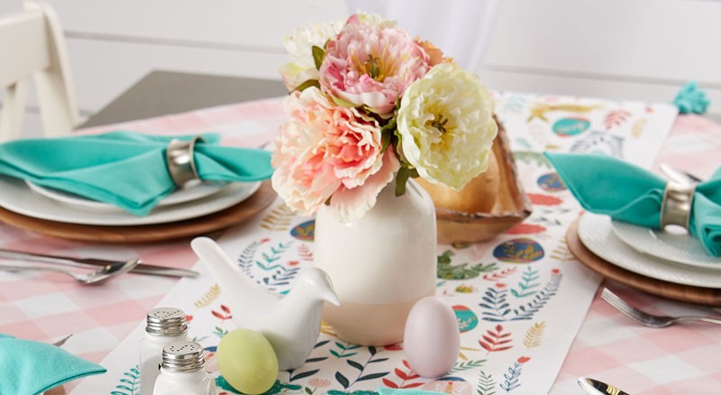 Table set for Easter with springtime colors, dyed eggs and place settings
