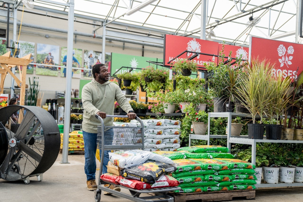 Image of person shopping for bags of soil at Tractor Supply.