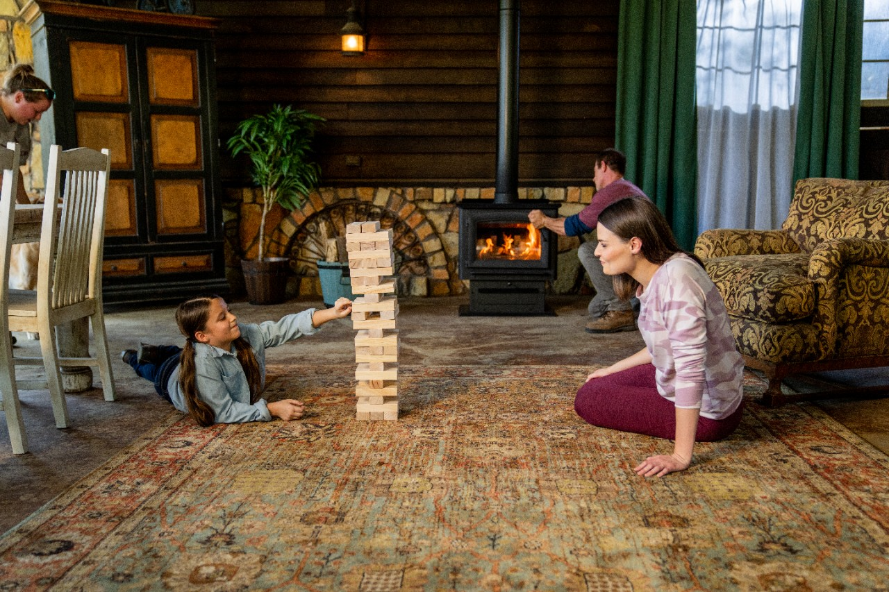 Image of a family playing jenga in front of a wood stove.