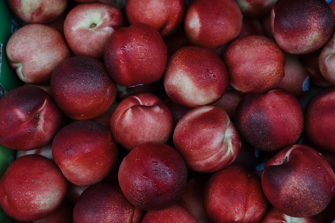 Image of red peaches in a pile.