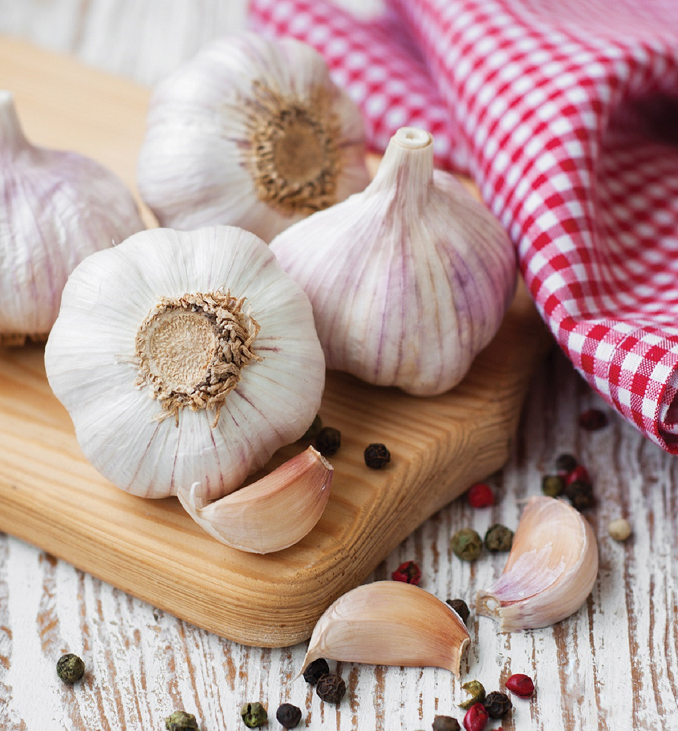 Image of garlic on a cutting board with a red and white napkin.
