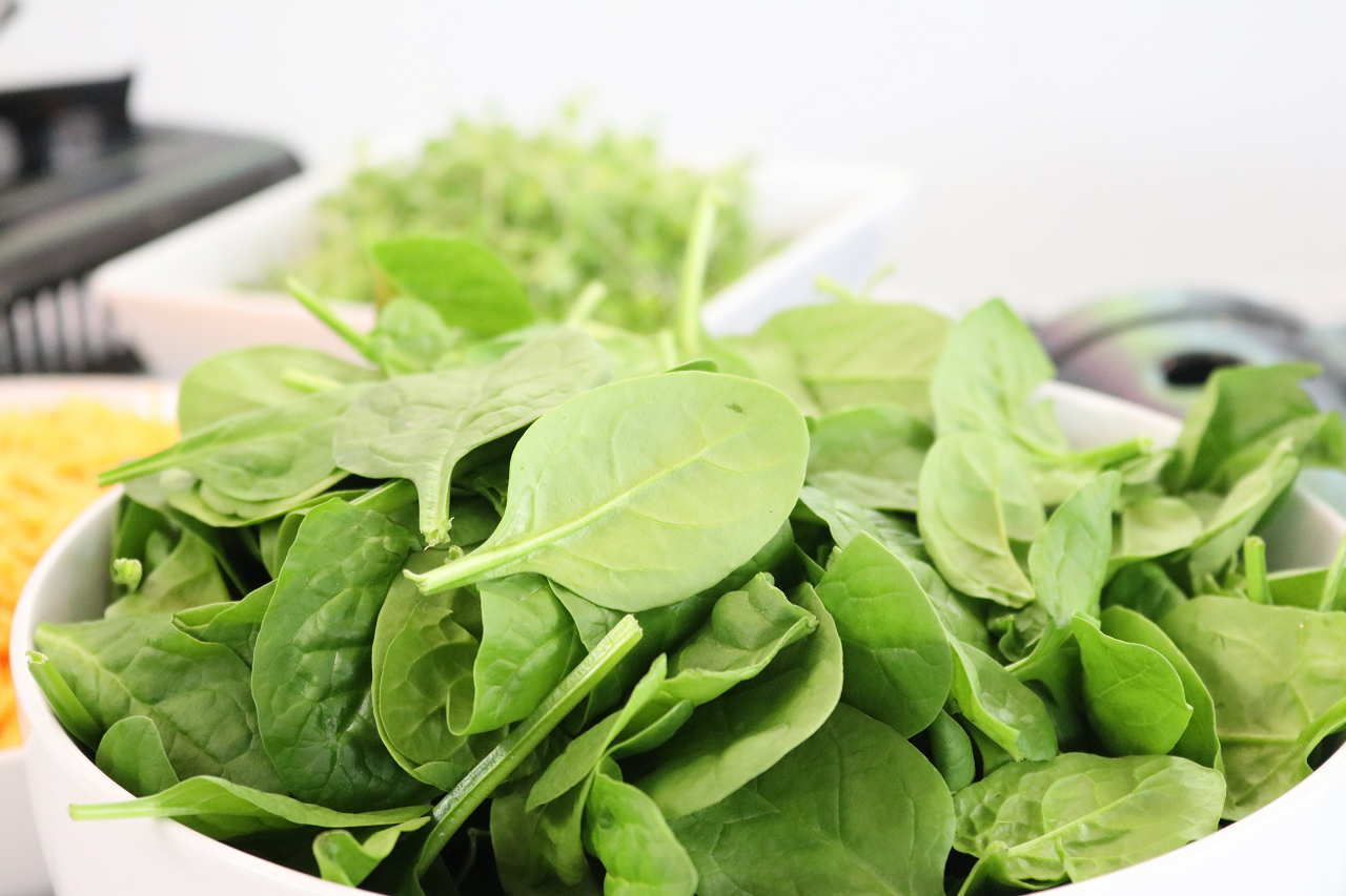 Image of fresh spinach in a white bowl.