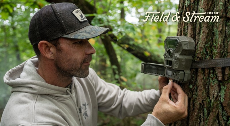 Man opening truck box to view his trail camera assortment.