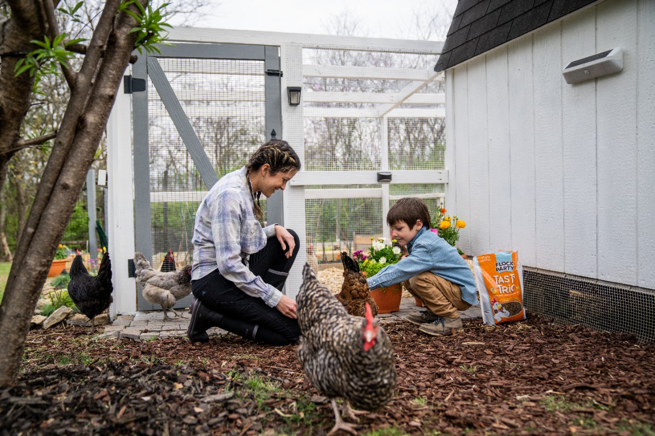 Image of two people in front of a chicken coop.