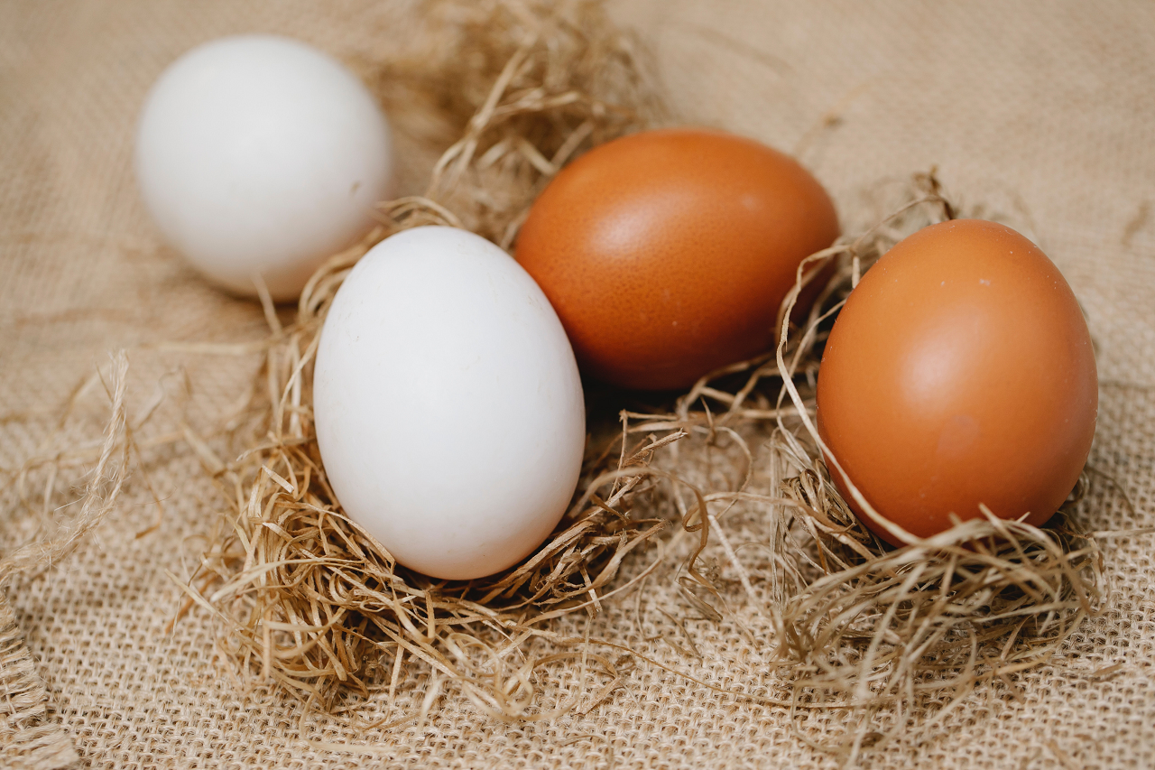 Image for white and brown eggs laying on a straw bag.