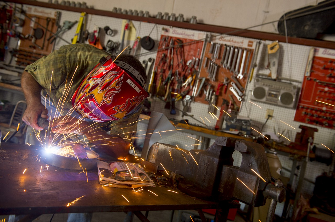 Image of a person repairing a metal patch using a welder.