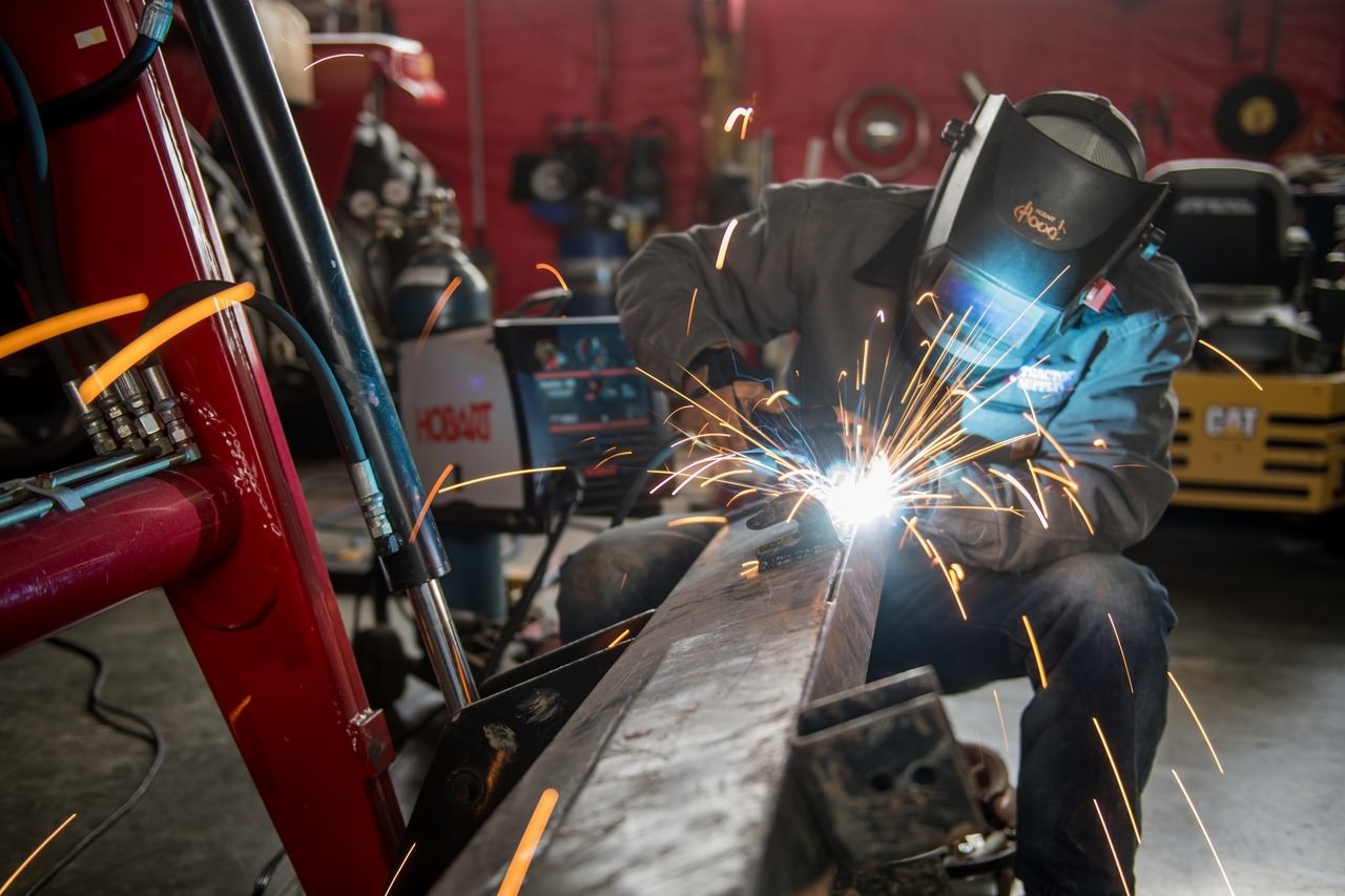 Image of a person welding in a garage.